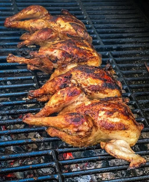 Pollos cocinándose sobre la parrilla de carbón